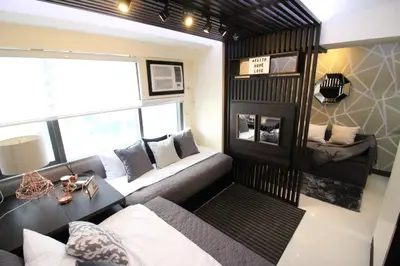 a living room with a couch and a fireplace at 5E Tower 2 Viceroy in Manila