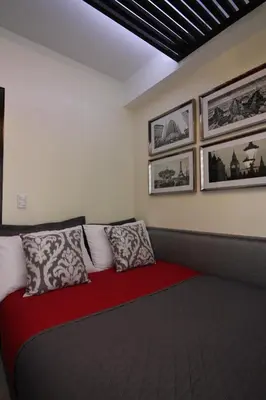 a room with a red bed with pillows on it at 5E Tower 2 Viceroy in Manila