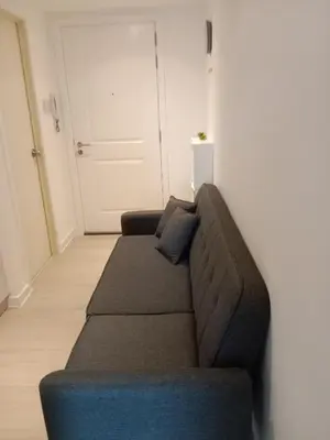 a brown couch in a room with a door at Azure Residences by Van Florendo in Manila