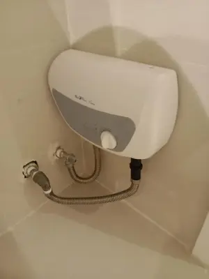 a toilet in a bathroom with a hose at Azure Residences by Van Florendo in Manila