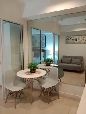 a living room with a table and chairs and a couch at Azure Residences by Van Florendo in Manila