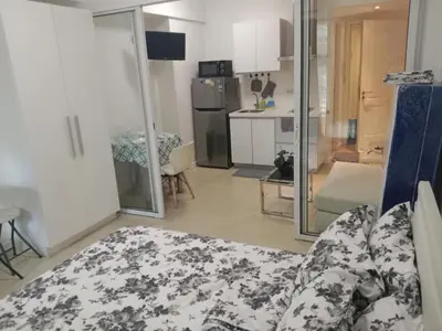 a living room with a couch and a kitchen at Azure Residences by Van Florendo in Manila