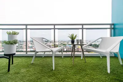 two white chairs and a table on a balcony at Azure Urban Beach Resort Manila by Radlett in Manila