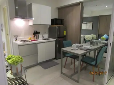 a kitchen with a table with chairs and a refrigerator at Azure Urban Beach Resort Manila by Radlett in Manila