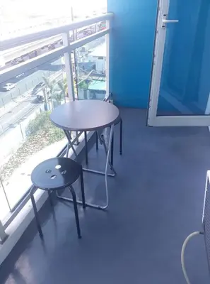 a table and stool in a room with a window at Joanne Sweet Home in Manila