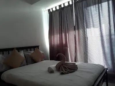 a swan decoration on a bed with a window at Joanne Sweet Home in Manila