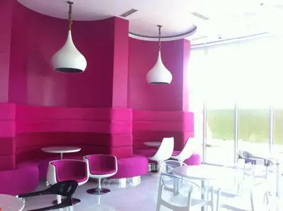 a restaurant with pink walls and tables and chairs at Joanne Sweet Home in Manila