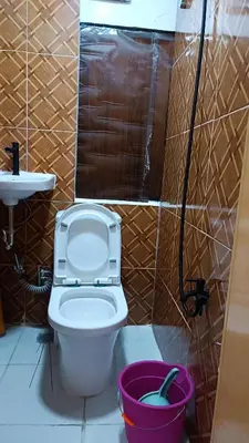 a bathroom with a toilet and a sink and a bucket at MJ Home in Manila