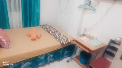 a small bedroom with a bed and a desk at MJ Home in Manila