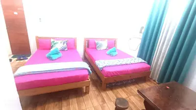 two beds with pillows on them in a room at MJ Home in Manila