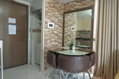 a table and chairs in a room with a brick wall at One Palm Tree Villas MANILA in Manila