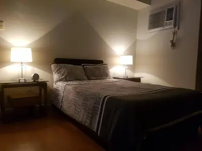 a bedroom with a bed with two lamps on it at Eton Baypark in Manila