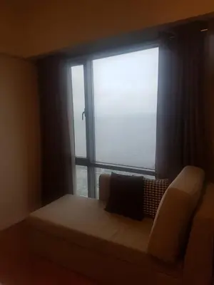 a room with a couch and a large window at Eton Baypark in Manila