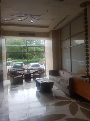 a living room with couches and tables and a large window at Eton Baypark in Manila