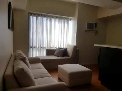 a living room with a couch and a window at Eton Baypark in Manila