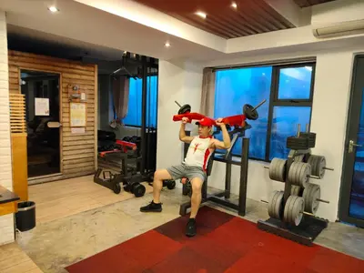 a man is sitting in a gym with a simulator at Heroes Hotel in Manila