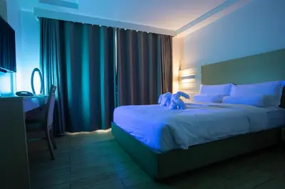 a bedroom with a bed with a teddy bear on it at Heroes Hotel in Manila