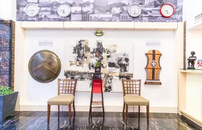 two chairs in front of a wall with clocks at Heroes Hotel in Manila