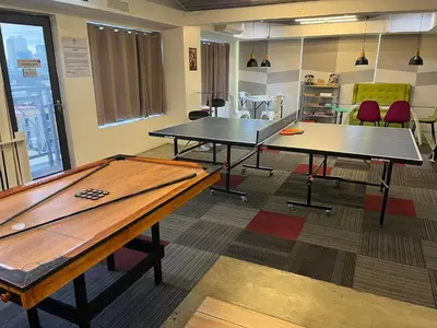 two ping pong tables in a room with pingpongs at Heroes Hotel in Manila