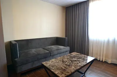 a living room with a couch and a table at Pearl Garden Hotel in Manila