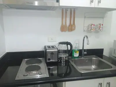 a kitchen counter with a stove and a sink at Jazz Hunter Residence in Manila