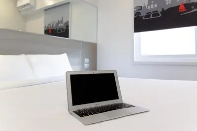 a laptop computer sitting on a table in a bedroom at Red Planet Manila Binondo in Manila
