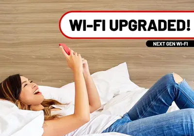 a woman laying on a bed with her phone at Red Planet Manila Binondo in Manila