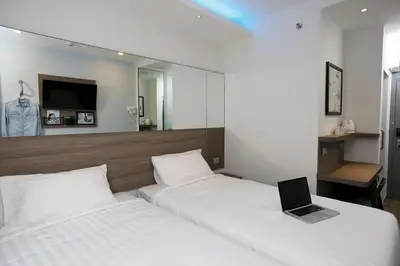 a bedroom with two beds with a laptop on it at Red Planet Manila Binondo in Manila