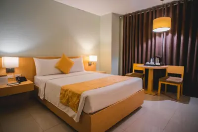 a hotel room with a large bed and a table at Manila Grand Opera Hotel in Manila