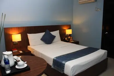 a hotel room with a bed and a table at Manila Grand Opera Hotel in Manila