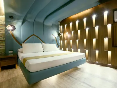 a bedroom with a bed in a blue room at Hotel Ava Malate in Manila