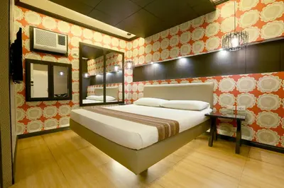 a bedroom with a large bed and a mirror at Hotel Ava Malate in Manila
