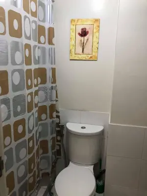 a bathroom with a toilet and a picture on the wall at Centropolis in Manila