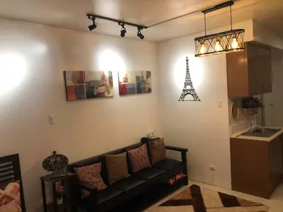 a living room with a couch and the eiffel tower at Centropolis in Manila