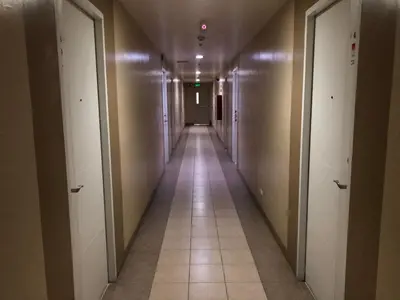 a long hallway with white doors and a tile floor at Centropolis in Manila