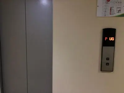 an elevator with a sign on a wall at Centropolis in Manila