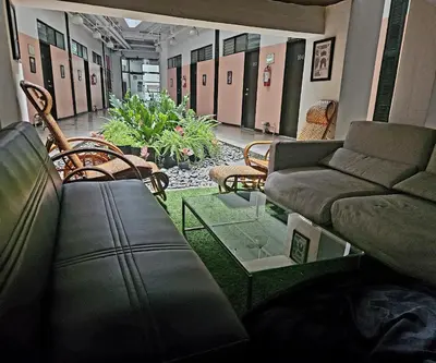 a living room with a couch and chairs in a room at Monchere Dormitory in Manila