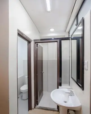 a bathroom with a sink and a toilet at Monchere Dormitory in Manila