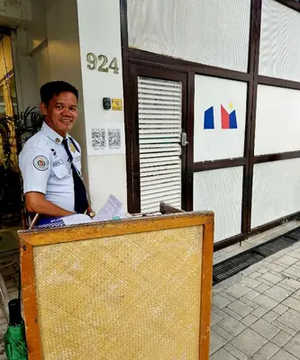 a man in uniform is standing behind a podium at Monchere Dormitory in Manila