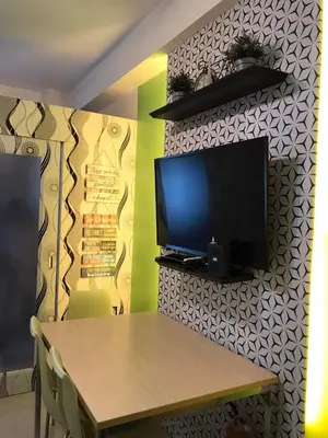 a dining room with a table and a television on a wall at SMDC Light Residences Condominium in Manila