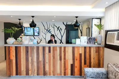 a woman standing behind a wooden bar in a lobby at Fersal Hotel - P. Tuazon Cubao in Manila