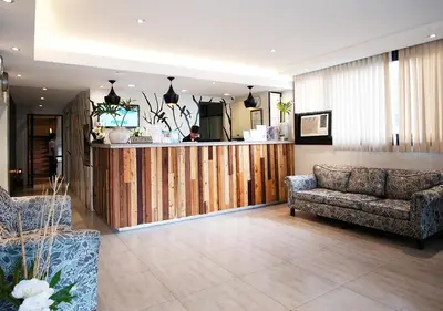 a living room with a couch and a bar at Fersal Hotel - P. Tuazon Cubao in Manila