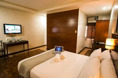 a hotel room with a bed with a laptop on it at Fersal Hotel - P. Tuazon Cubao in Manila