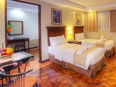 a hotel room with two beds and a desk at Fersal Hotel - P. Tuazon Cubao in Manila