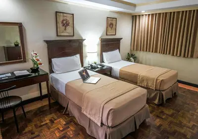 a hotel room with two beds and a desk at Fersal Hotel - P. Tuazon Cubao in Manila