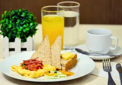 a plate of breakfast food with toast and cheese and orange juice at Fersal Hotel Neptune Makati in Manila