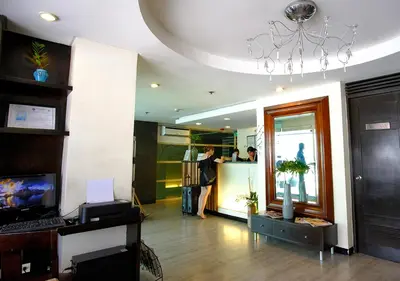 a lobby of a building with people standing at a counter at Fersal Hotel Neptune Makati in Manila