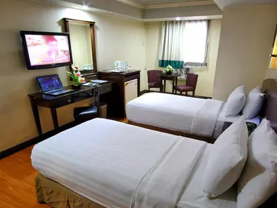 a hotel room with two beds and a television at Fersal Hotel - Manila in Manila