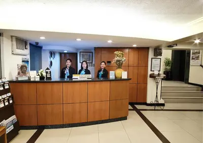 a group of people standing at a counter in a lobby at Fersal Hotel - Manila in Manila