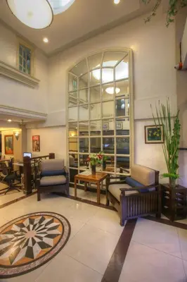 a lobby with chairs and tables and a large window at Fersal Hotel - Manila in Manila